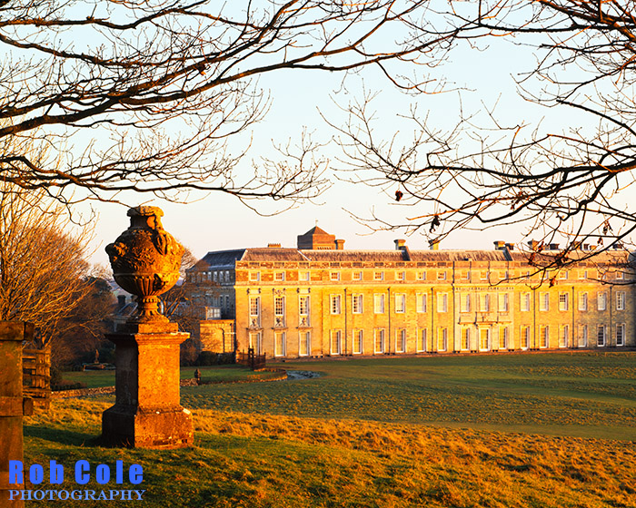 Warm light at sunset illuminates Petworth House on a freezing winter afternoon